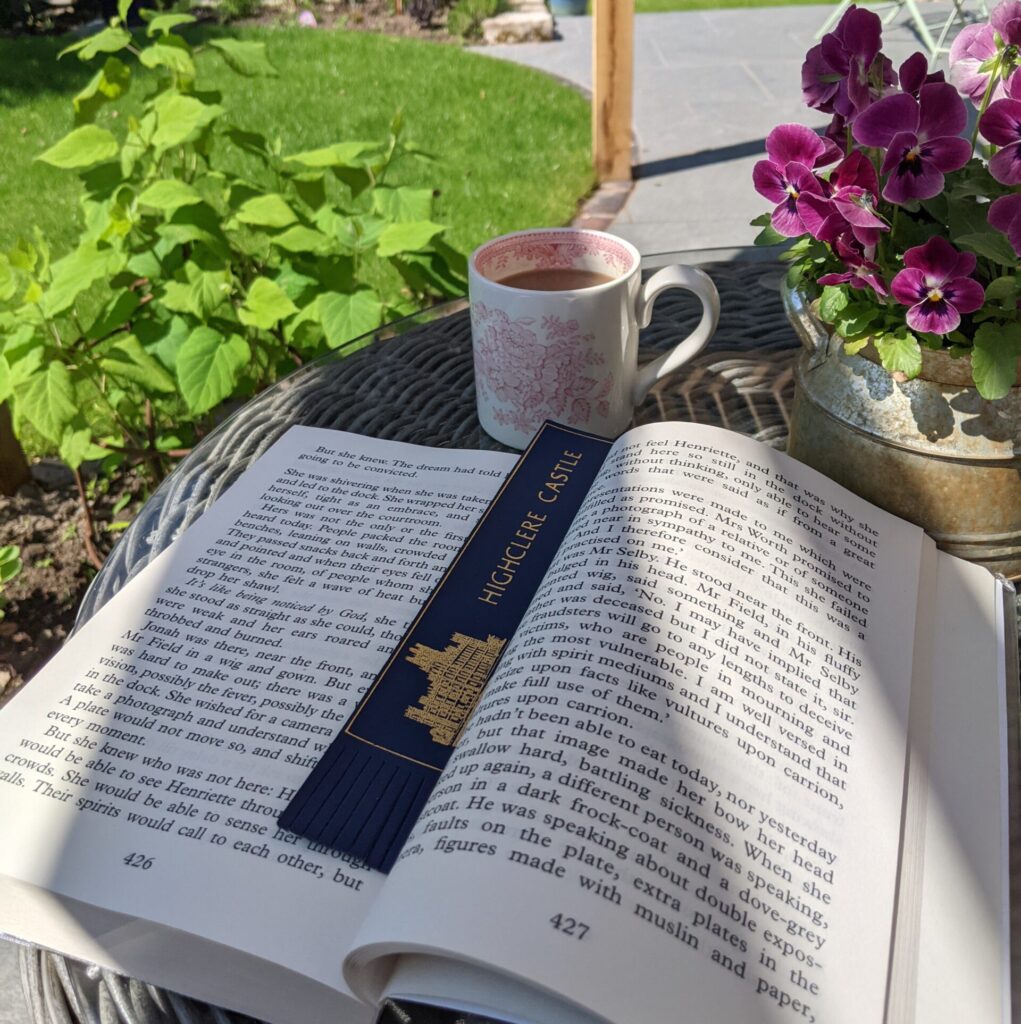 reading book outside cup of tea